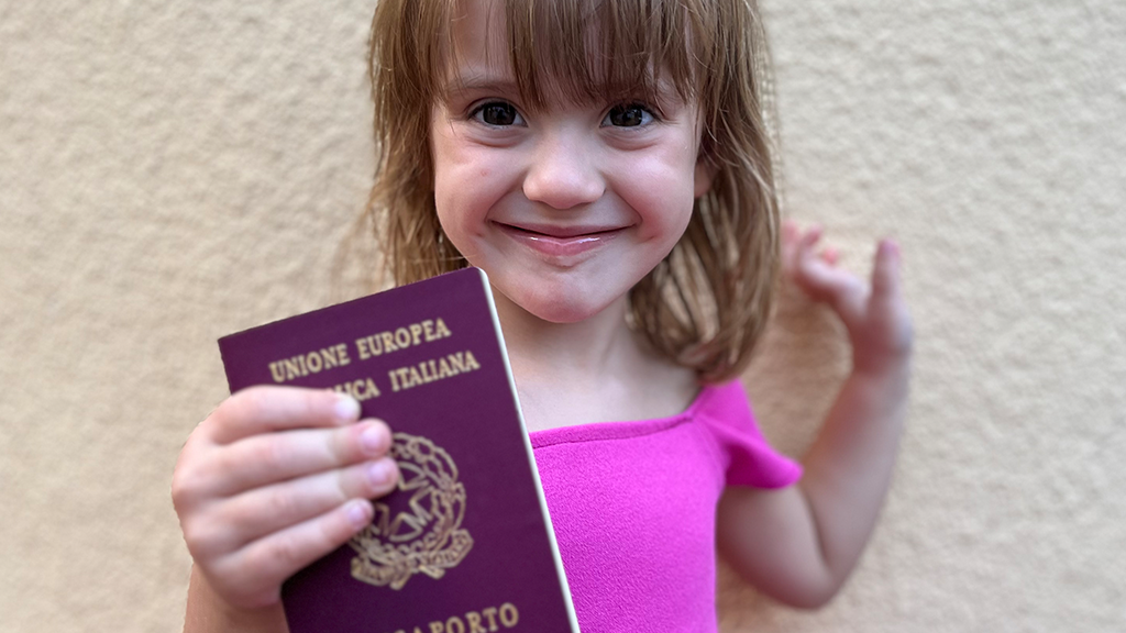 Niña pequeña sosteniendo pasaporte italiano
