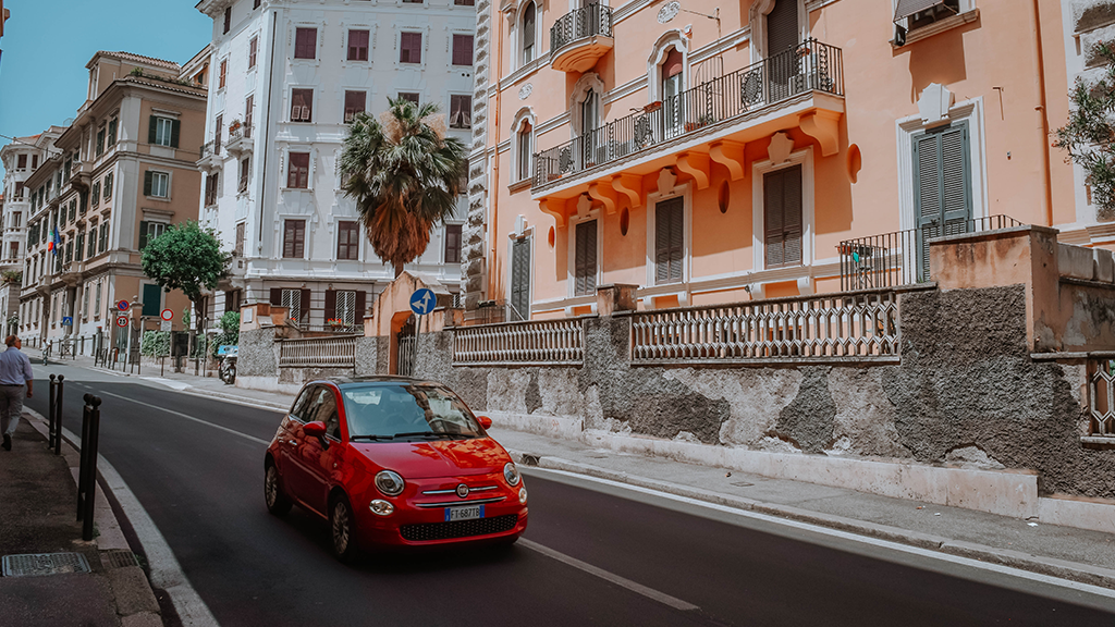 Auto rojo paseando por las calles de algún pueblo de Italia